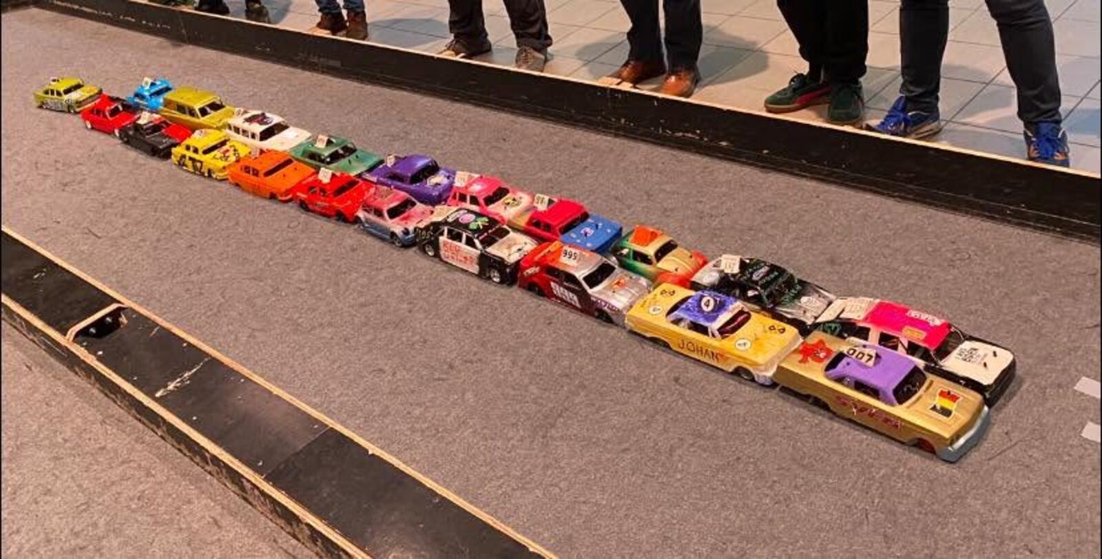 Een rij zelfgebouwde RC bangers op de baan, klaar voor de start.